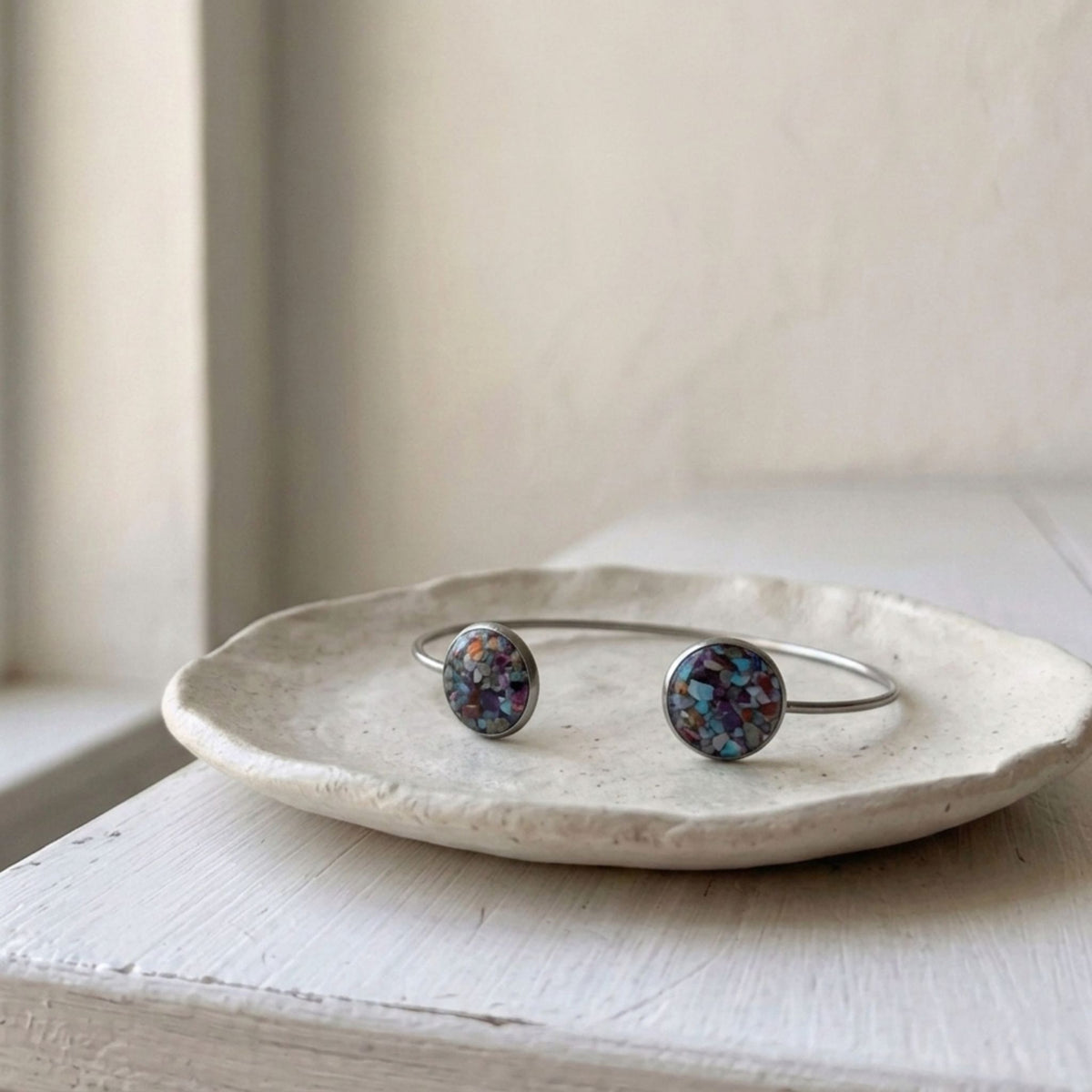 Handcrafted with a sleek stainless steel open cuff design, this elegant bangle features two round bezels filled with natural crushed Imperial Jasper - Kiooinsitu