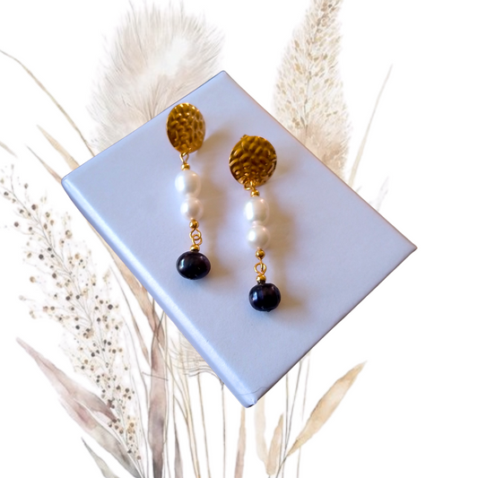 Add a touch of glamour to your look with our golden stainless steel drop earrings adorned with white freshwater pearls and midnight blue freshwater pearl.