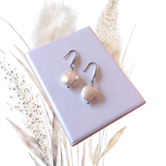 Add a touch of elegance to your look with these handmade Freshwater Coin Pearl Drop Earrings. A 12 mm Coin Pearl drops gracefully from elegant stainless steel hooks for an exquisite look that's sure to turn heads.