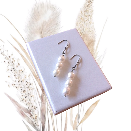 Be the envy of all your friends with these stunning, handmade White Freshwater Pearl Drop Earrings! Three freshwater pearls dangle gracefully below elegant stainless steel ear hooks,
