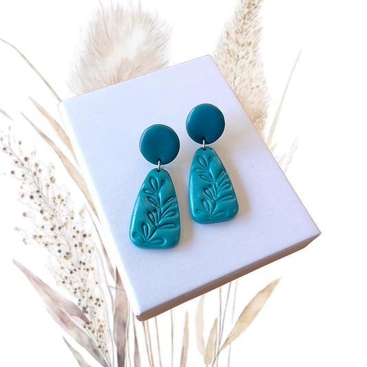 Indulge in luxury with our exquisite Polymer Clay Drop Earrings. Each pair is handmade and features a stunning turquoise color, embossed with a delicate leaf print.