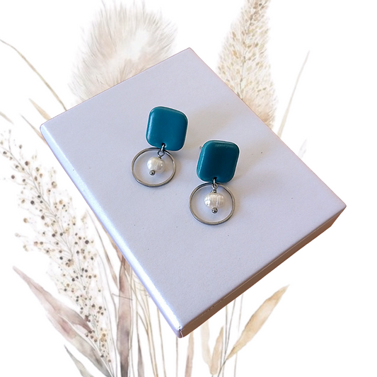Indulge in the exquisite elegance of our Polymer Clay &amp; Freshwater Pearl Drop Earrings. Handmade with stunning midnight blue freshwater pearls, these earrings feature square turquois polymer clay studs with a stainless steel pin