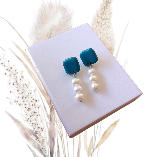 Indulge in the exquisite elegance of our Polymer Clay &amp; Freshwater Pearl Drop Earrings. Handmade with stunning white freshwater pearls, these earrings feature square turquois polymer clay studs with a stainless steel pin.