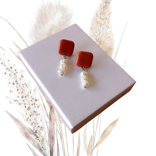 Indulge in the exquisite elegance of our Polymer Clay &amp; Freshwater Pearl Drop Earrings. Handmade with stunning white freshwater pearls, these earrings feature square tan polymer clay studs with a stainless steel pin.