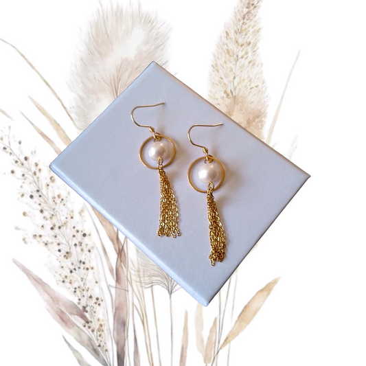 Add a touch of glamour to your look with our golden stainless steel drop earrings adorned with white freshwater pearls.