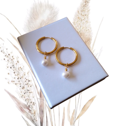 Our stunning Gold Stainless Steel Hoop Earrings, featuring exquisite white freshwater pearls measuring 7mm in diameter.
