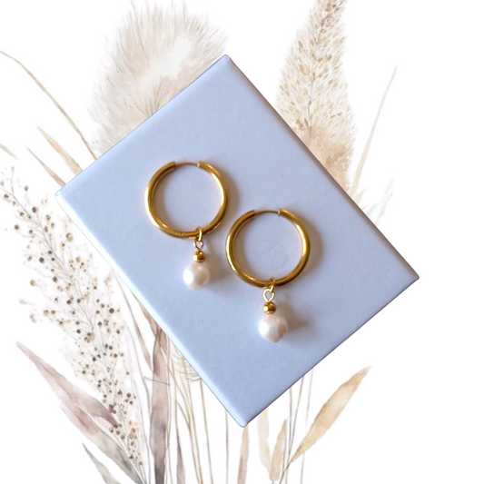 Our stunning Gold Stainless Steel Hoop Earrings, featuring exquisite white freshwater pearls measuring 7mm in diameter. 