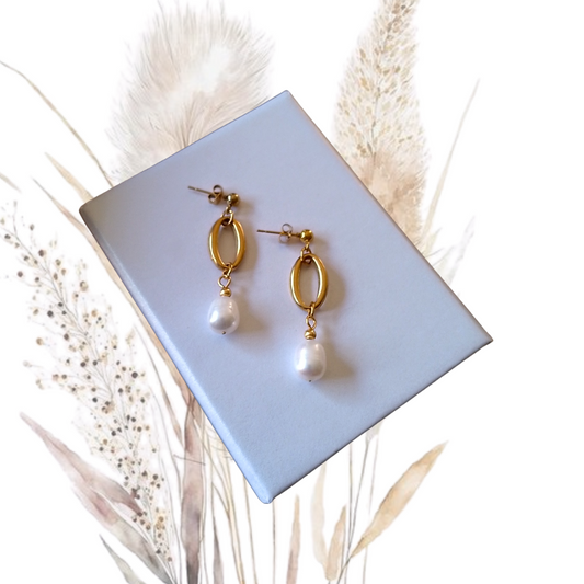 Add a touch of glamour to your look with our golden stainless steel drop earrings adorned with white freshwater pearls
