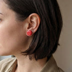 Woman wearing 14mm salmon pink polymer clay stud earrings - lifestyle shot