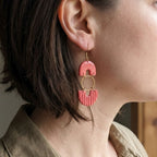 Woman wearing salmon pink arch and ribbed fan polymer clay dangle earrings with gold hardware - lifestyle shot