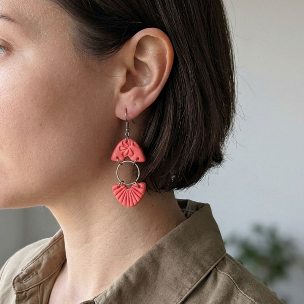 Woman wearing salmon pink textured fan polymer clay dangle earrings - lifestyle shot
