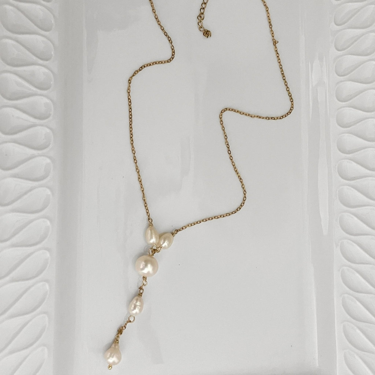 Handmade freshwater pearl Y necklace features an 8 mm off-round white pearl, with four smaller natural white freshwater pearls placed along the chain and drop detail.