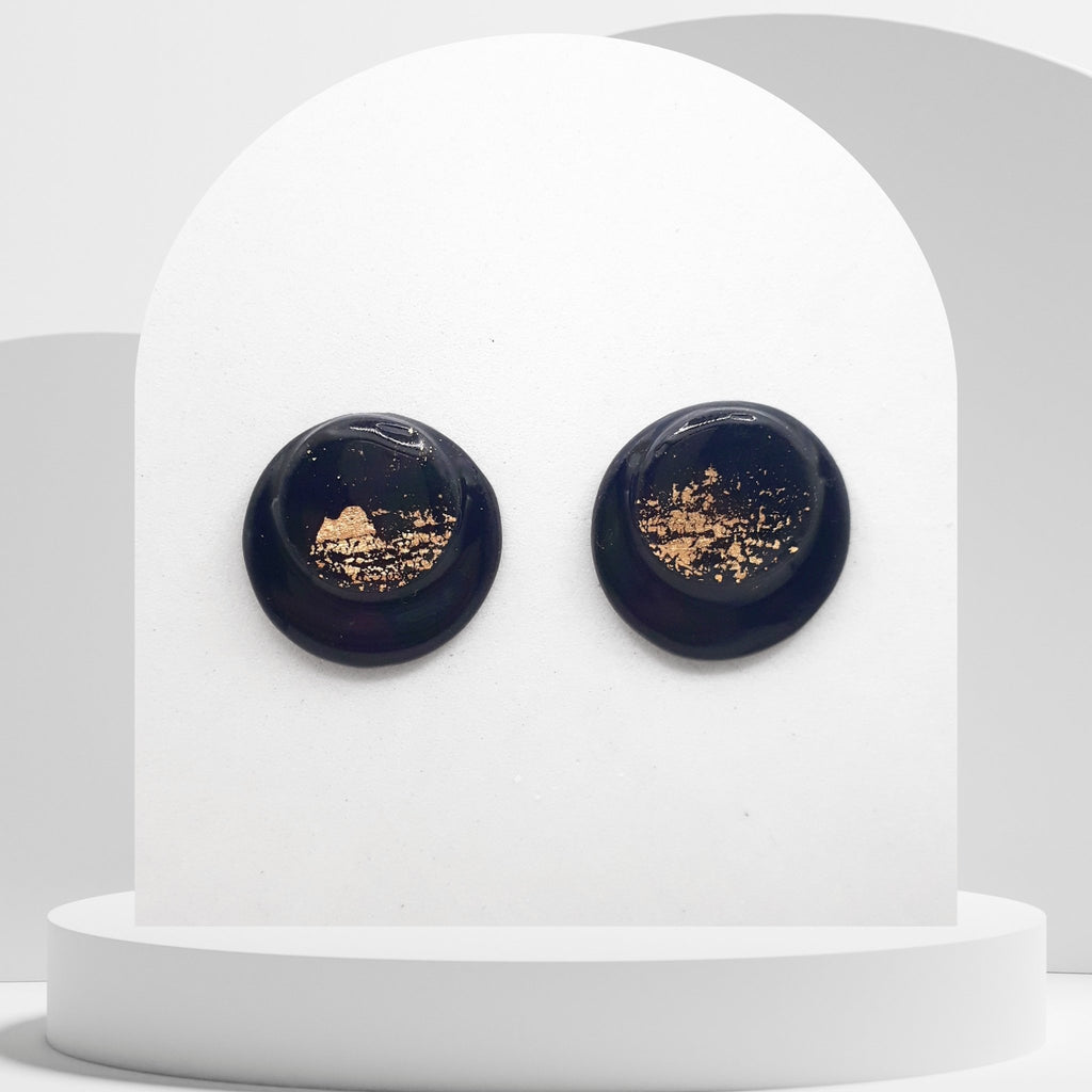 Handmade black polymer clay stud earrings with gold leaf and resin finish