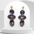 Handmade black and gold leaf polymer clay dangle earrings with geometric oval design