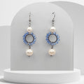 Handmade stainless steel dangle earrings with light blue glass beads, featuring two natural white freshwater pearls and circular beaded design