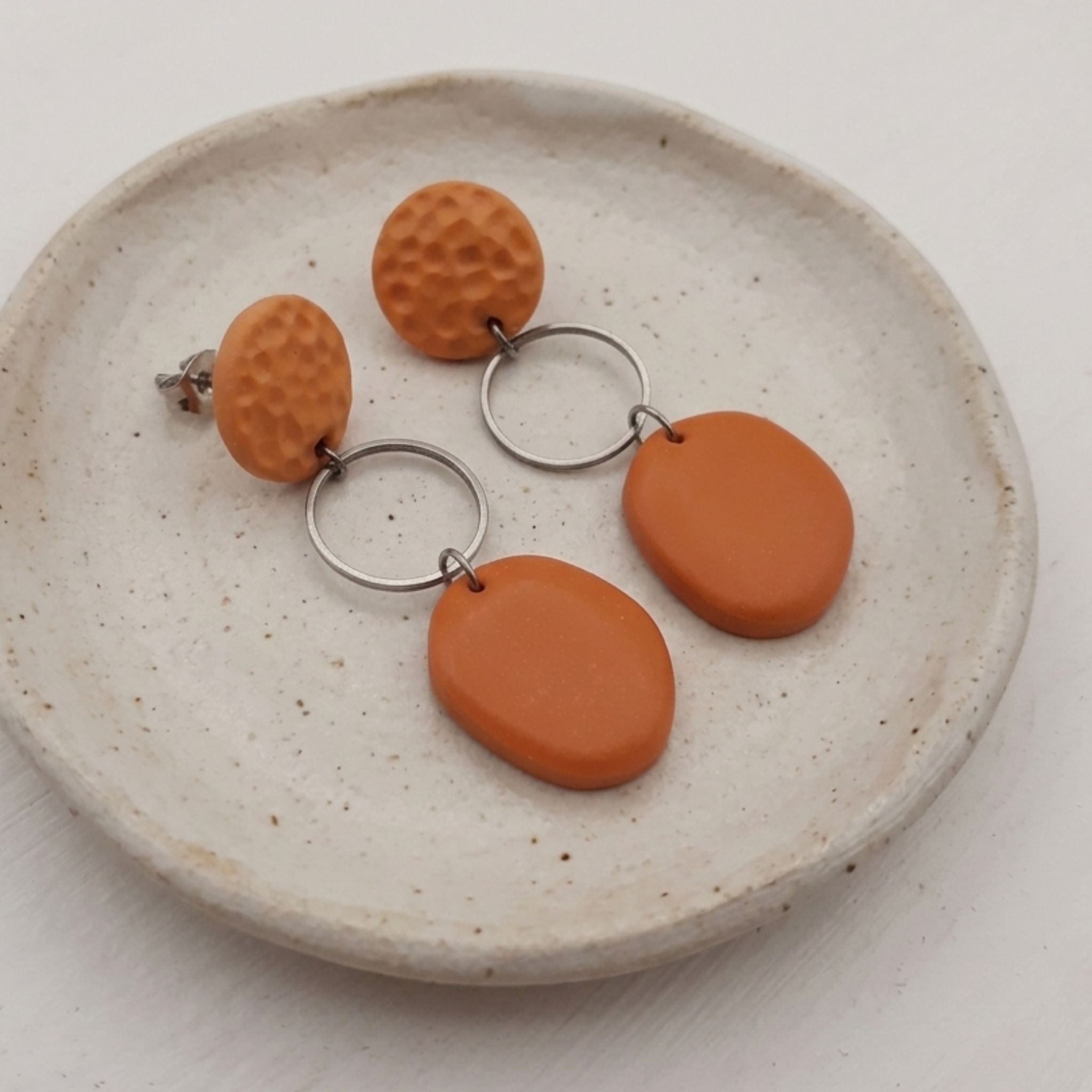 Burnt orange textured polymer clay dangle earrings with stainless steel ear pins and silver rings