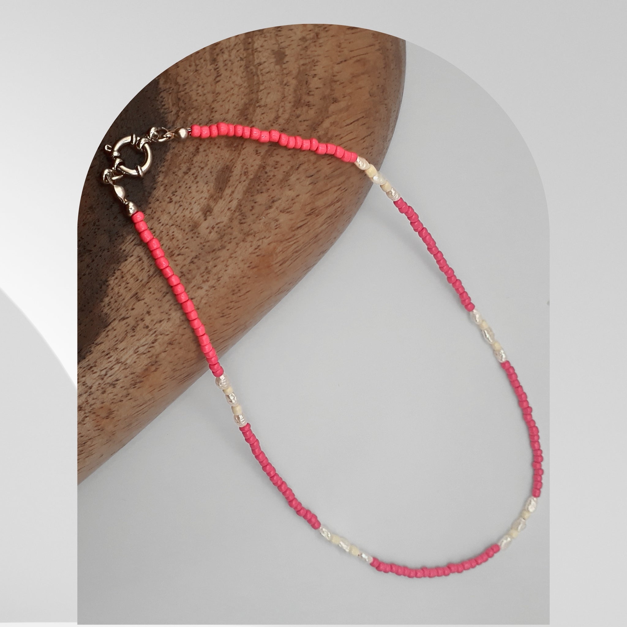 Handmade necklace featuring freshwater rice pearls and cerise pink glass beads with a stainless steel spring ring clasp.