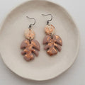 Mauve polymer clay Monstera leaf earrings with copper metallic flecks and stainless steel shepherd ear hooks