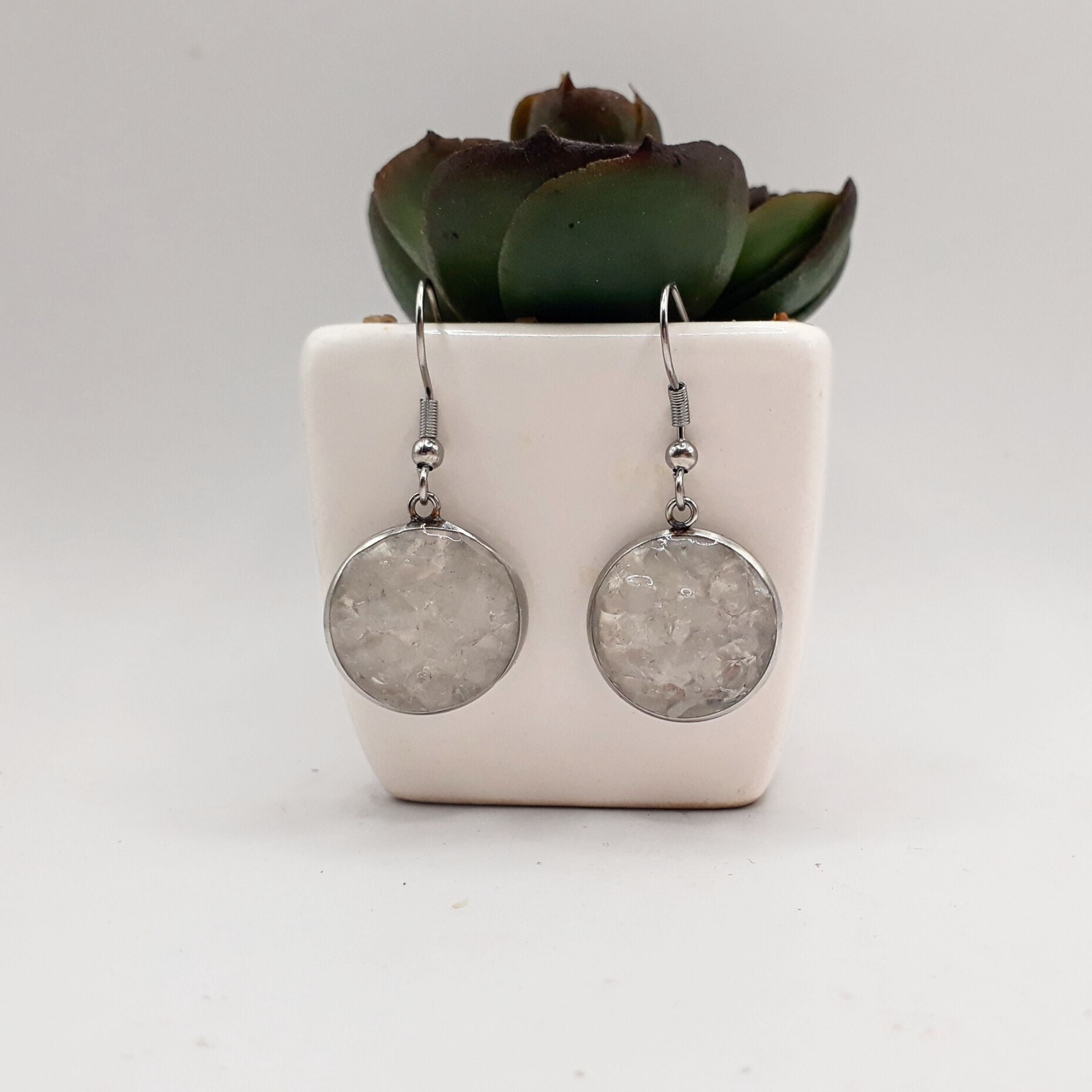 Handcrafted earrings with crushed clear quartz set in 16 mm stainless steel bezels, sealed with resin, hanging from stainless steel shepherd hooks.