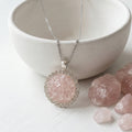 Handmade rose quartz round pendant necklace with crushed gemstones, rhinestone border and stainless steel cable chain.