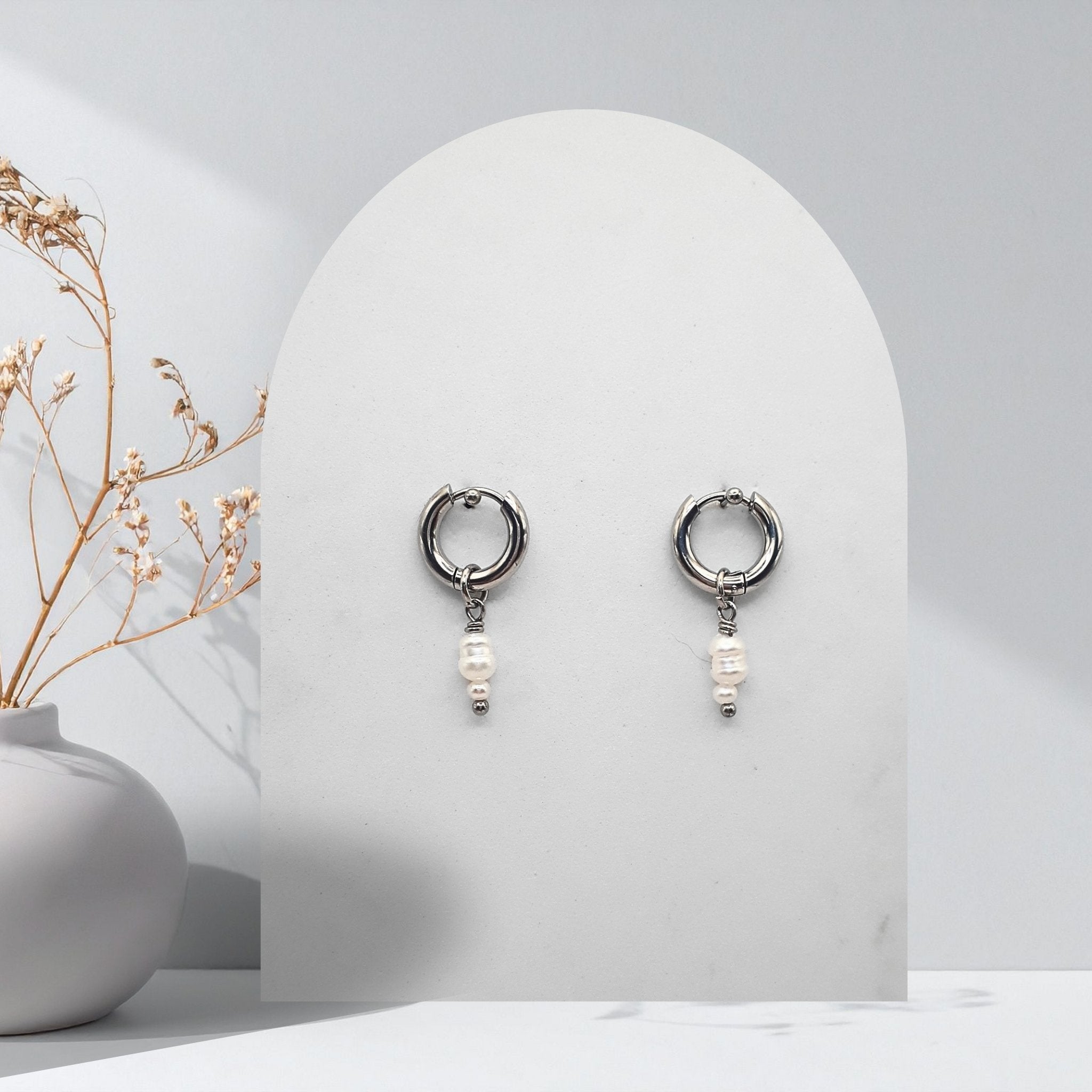 Handmade 316L stainless steel 12 mm huggie hoop earrings with removable natural white freshwater rice pearl charms.