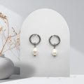 Handmade 316L stainless steel 16 mm huggie hoop earrings with removable 7 mm pear-shaped natural freshwater pearl charms.