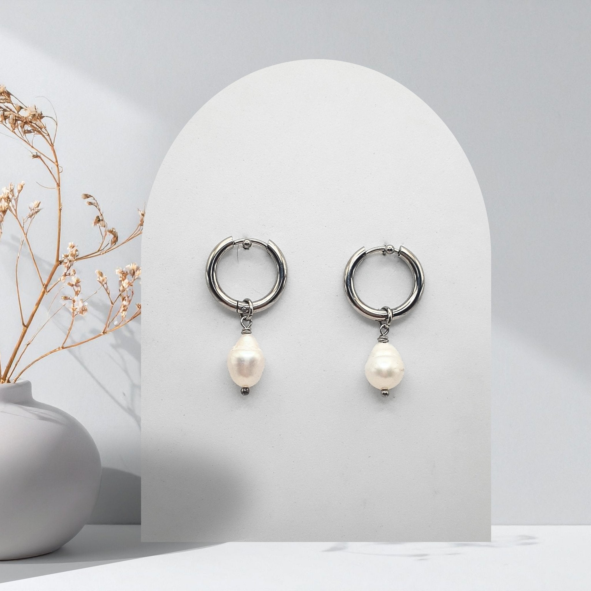 Handmade 316L stainless steel 16 mm huggie hoop earrings with removable 7 mm pear-shaped natural freshwater pearl charms.