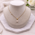 Gold-plated stainless steel necklace with 7mm freshwater pearl and white ceramic heart detail, adjustable 45cm chain with 5cm extension