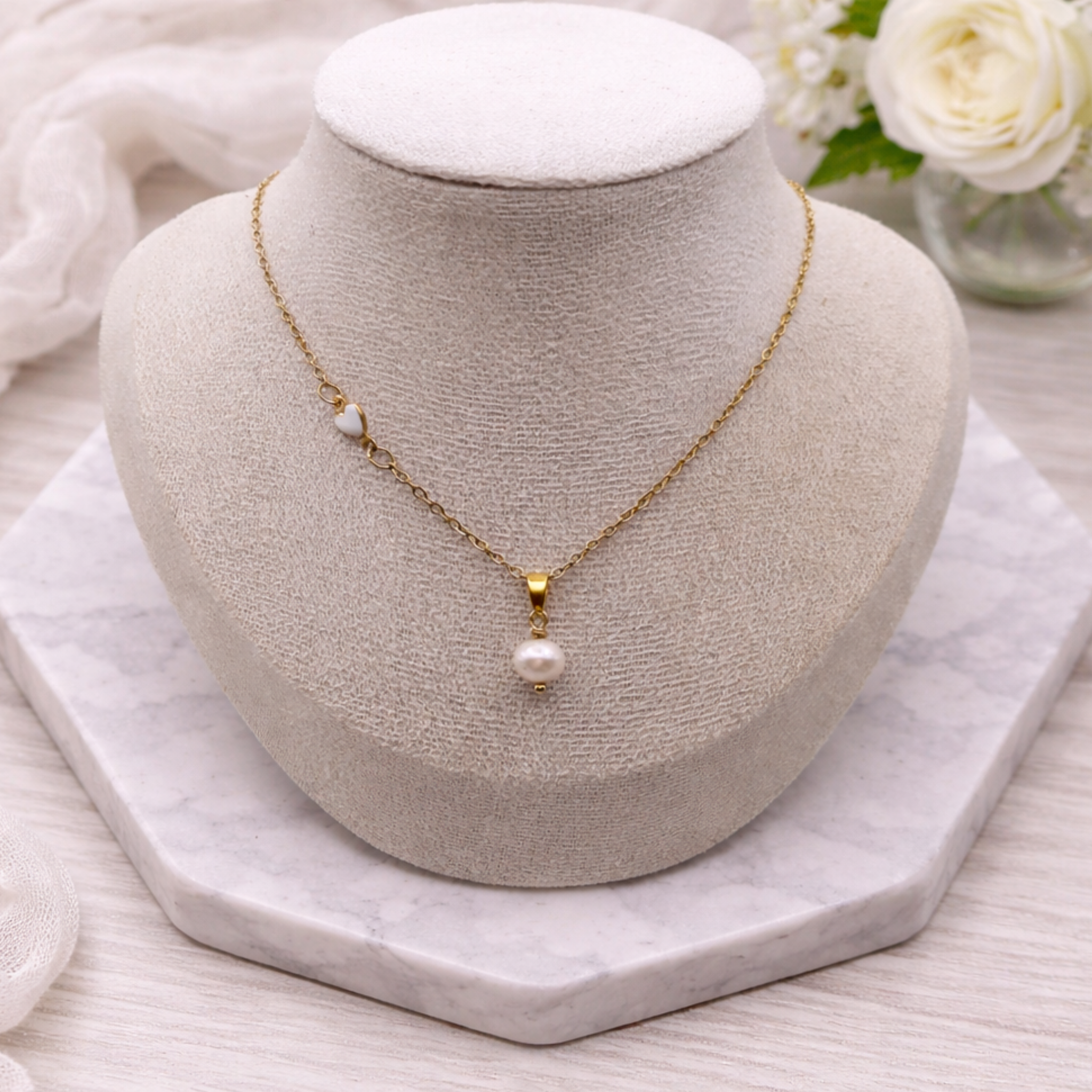 Gold-plated stainless steel necklace with 7mm freshwater pearl and white ceramic heart detail, adjustable 45cm chain with 5cm extension