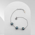 Handmade stainless steel bracelet featuring three dark green freshwater pearls accented with white rice pearls on a cable chain.