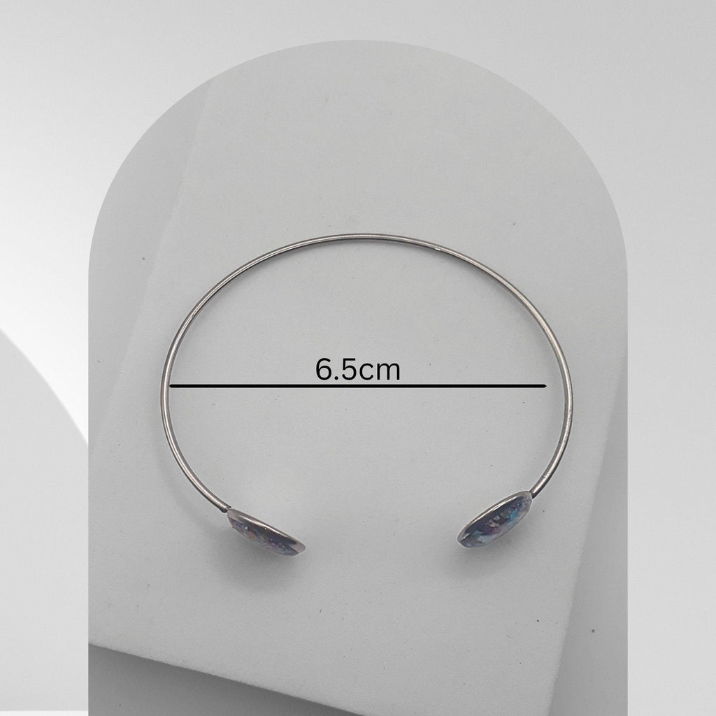 Silver bracelet with gemstones on a white background, showing measurement of 6.5cm.