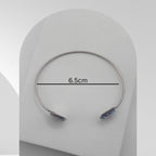 Silver bracelet with gemstones on a white background, showing measurement of 6.5cm.