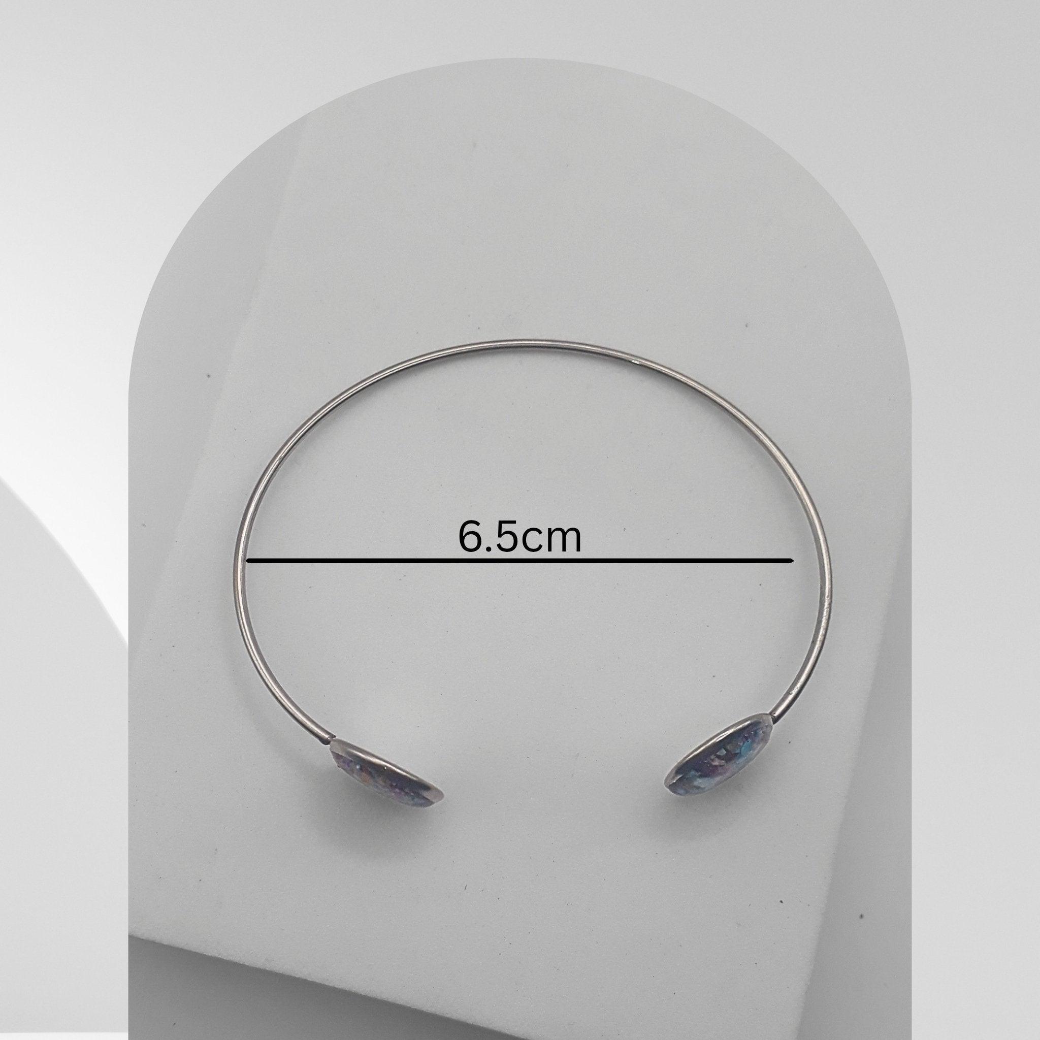 Silver bracelet with gemstones on a white background, showing measurement of 6.5cm.