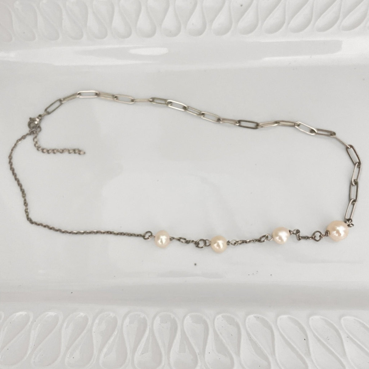 Handmade Freshwater Pearl & Paperclip Chain Necklace on a white ceramic plate.