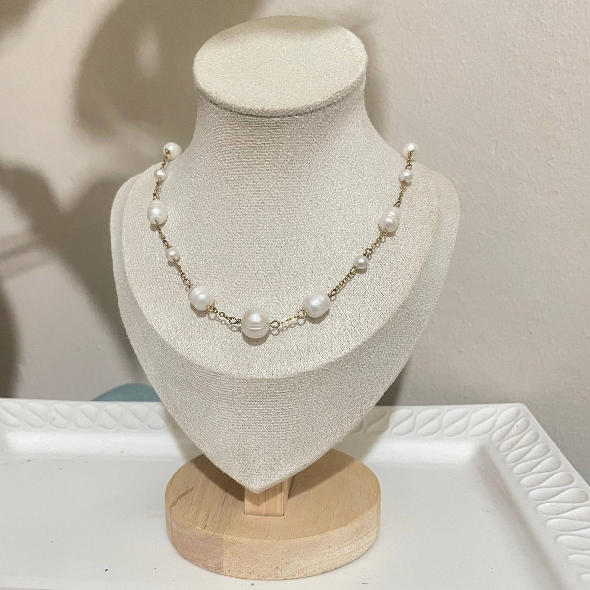 Handmade scattered freshwater pearl stainless-steel gold-plated necklace on a bust.