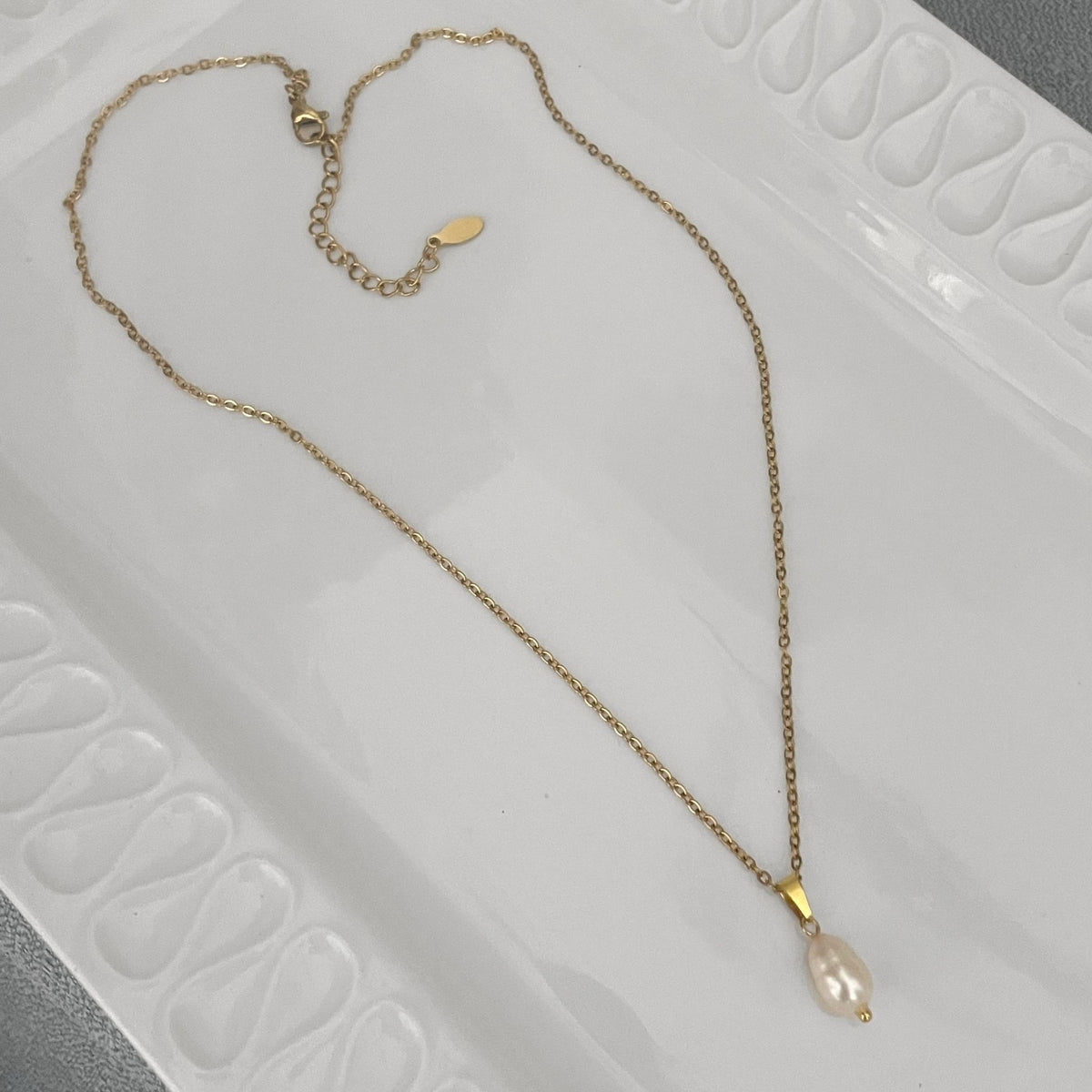 White Freshwater Pearl Teardrop Necklace – Gold-Plated Stainless Steel on a white ceramic plate