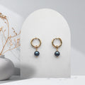 Handmade 316L gold-plated stainless steel 14 mm huggie hoop earrings with removable 7 mm natural midnight blue freshwater pearl charms.