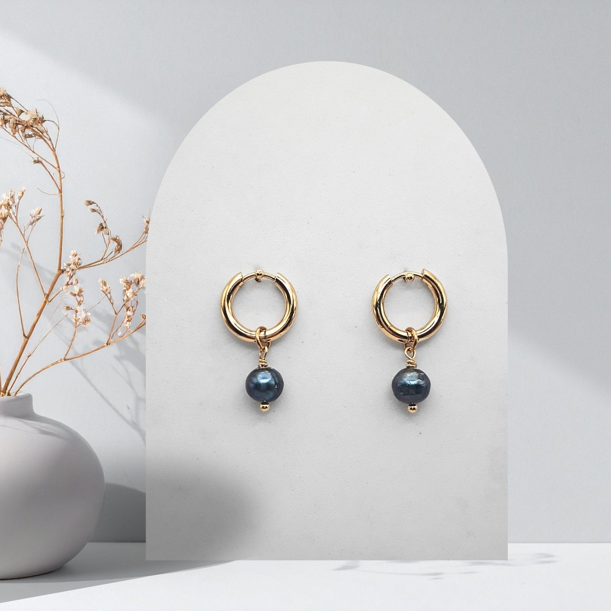 Handmade 316L gold-plated stainless steel 14 mm huggie hoop earrings with removable 7 mm natural midnight blue freshwater pearl charms.