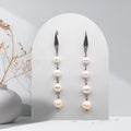 Handmade stainless steel cascade earrings featuring natural white freshwater pearls in graduating 6 mm, 7 mm, 8 mm and 9 mm sizes.