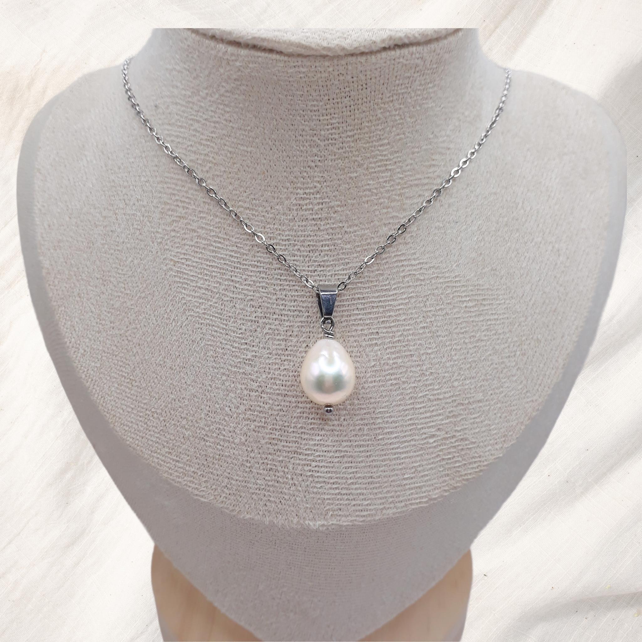 Handcrafted stainless steel necklace with an 11 mm white teardrop freshwater pearl pendant on a 45 cm chain displayed on a jewelry stand.