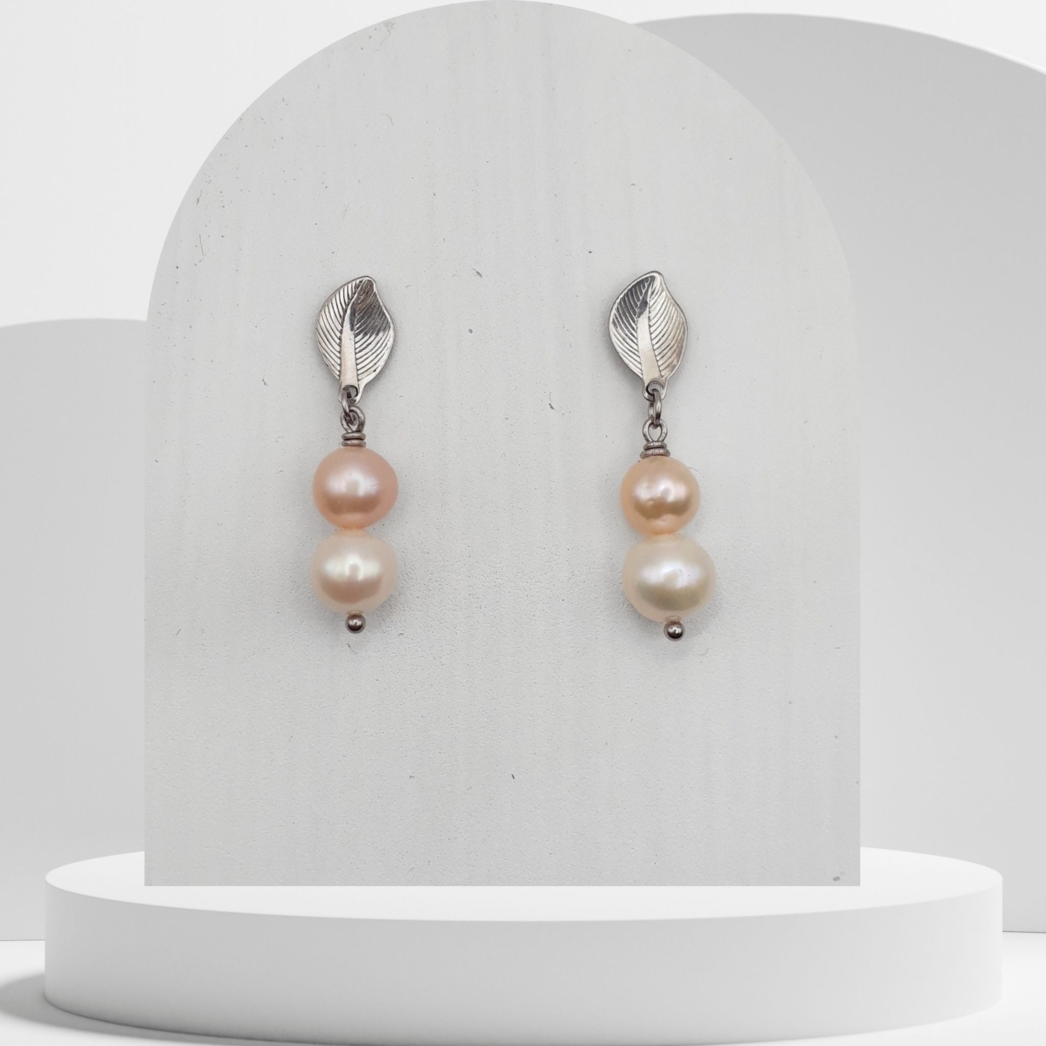 Handmade drop earrings with peach and white freshwater pearls on stainless steel leaf studs