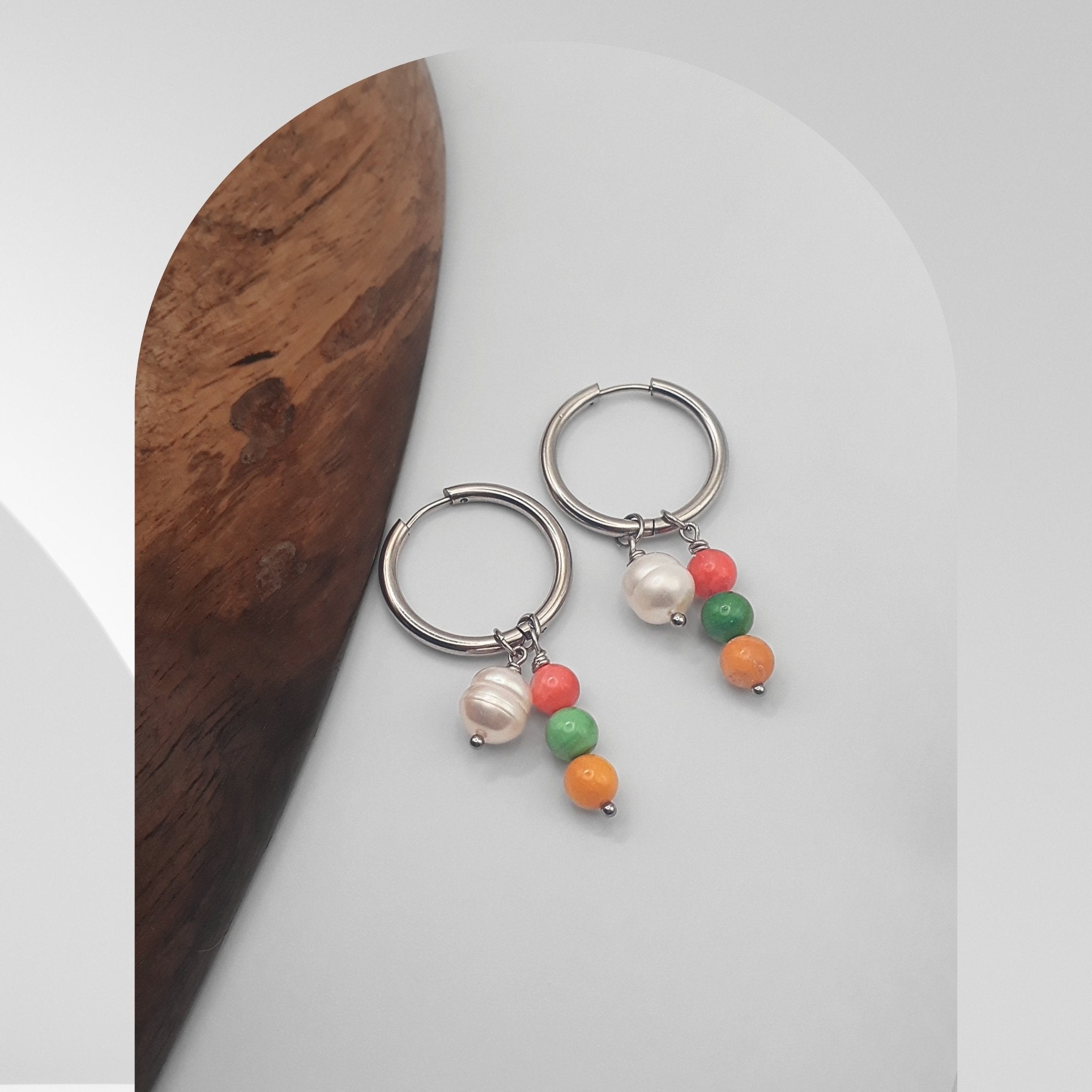 Handmade 25mm stainless steel hoop earrings with pear-shaped freshwater pearl charms and multicolour glass bead charms.