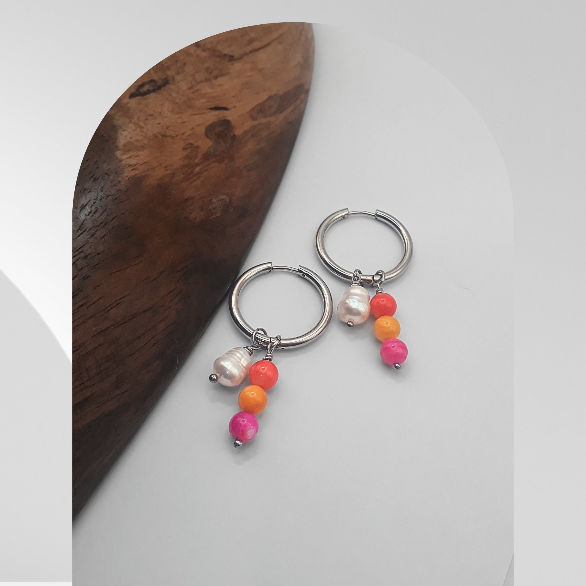 Handmade 25mm stainless steel hoop earrings with pear-shaped freshwater pearl charms and multicolour glass bead charms.