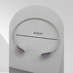 Handmade stainless steel open cuff bangle with crushed Pink Aura Quartz sealed in resin