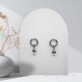 Handmade 316L stainless steel 12 mm huggie hoop earrings with removable natural silver and white freshwater rice pearl charms.