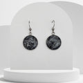 Stainless steel drop earrings with 18mm bezel set crushed snowflake obsidian gemstones sealed in resin on shepherd hooks