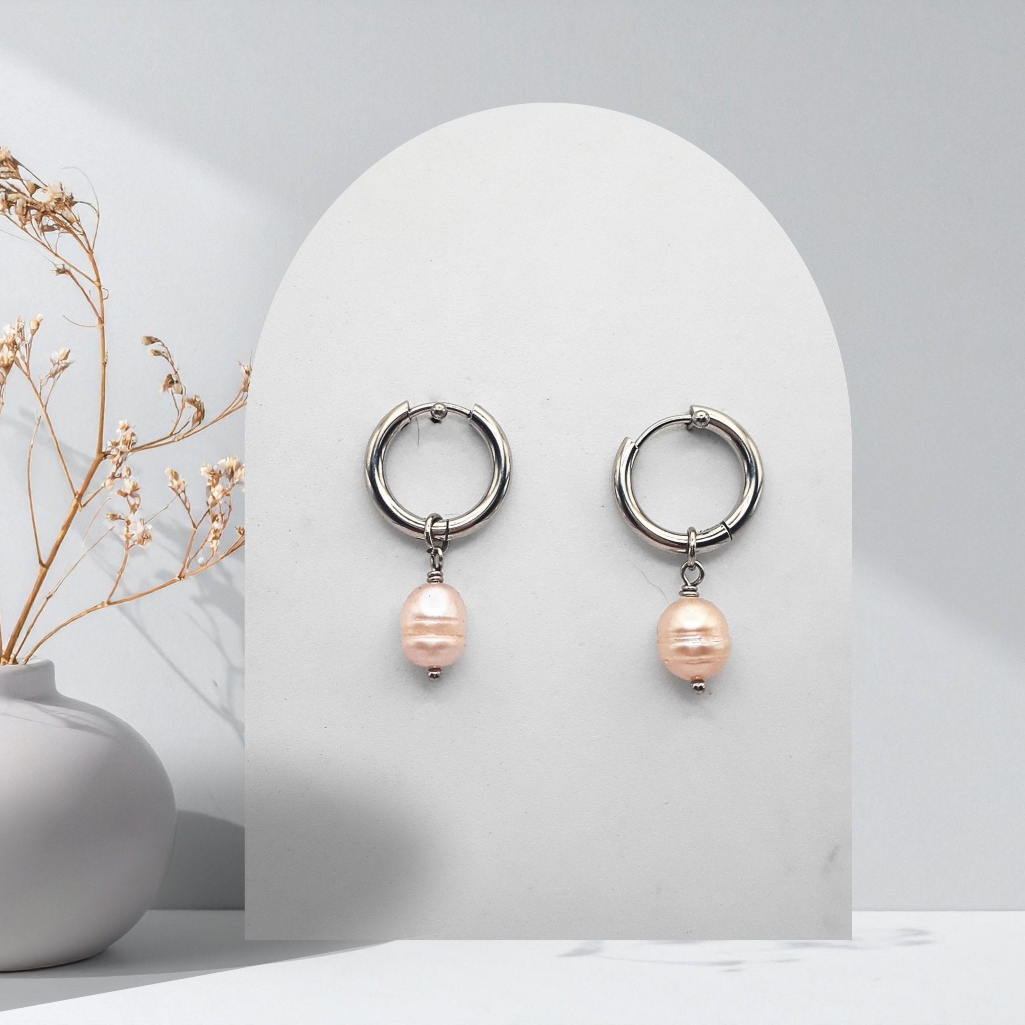 Handmade 316L stainless steel 16 mm huggie hoop earrings with removable 7 mm soft pink pear-shaped natural freshwater pearl charms.