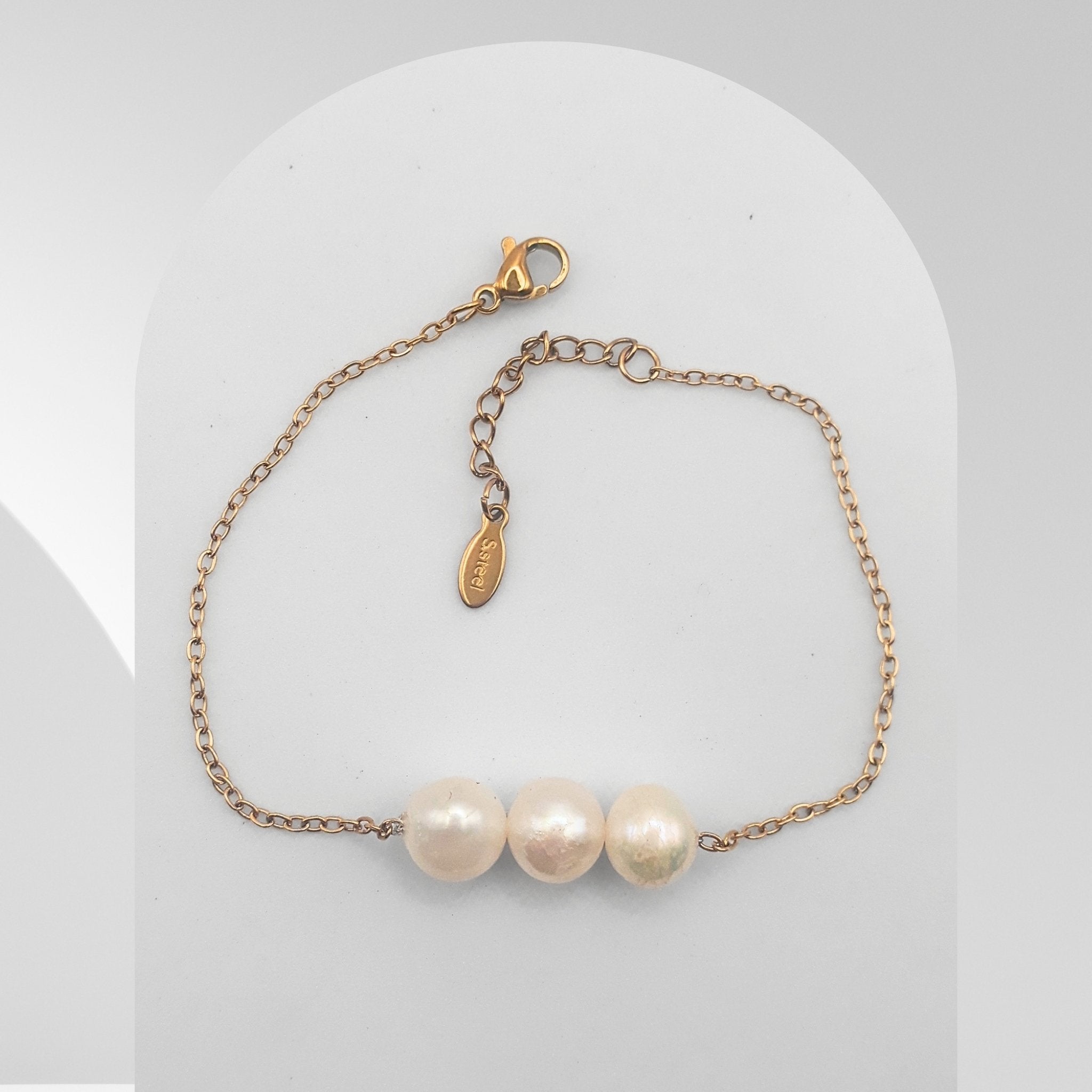 Three Pearl bracelet with gold chain on a white background