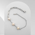 Silver bracelet with pearls on a light gray background