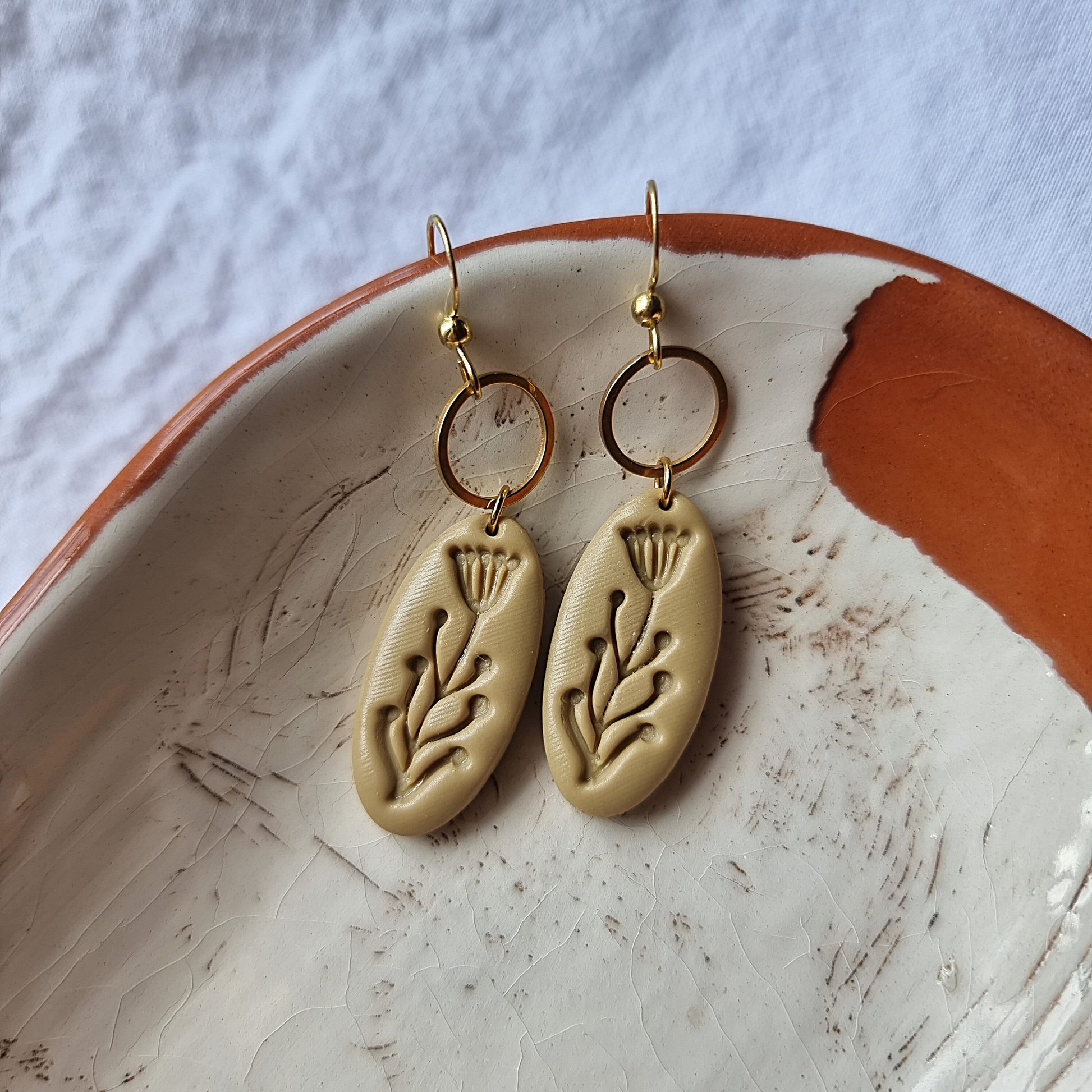 Elegance in simplicity with our unique oval-shaped polymer clay earrings. Earthy colors and delicate flower embossing add a touch of nature-inspired charm.